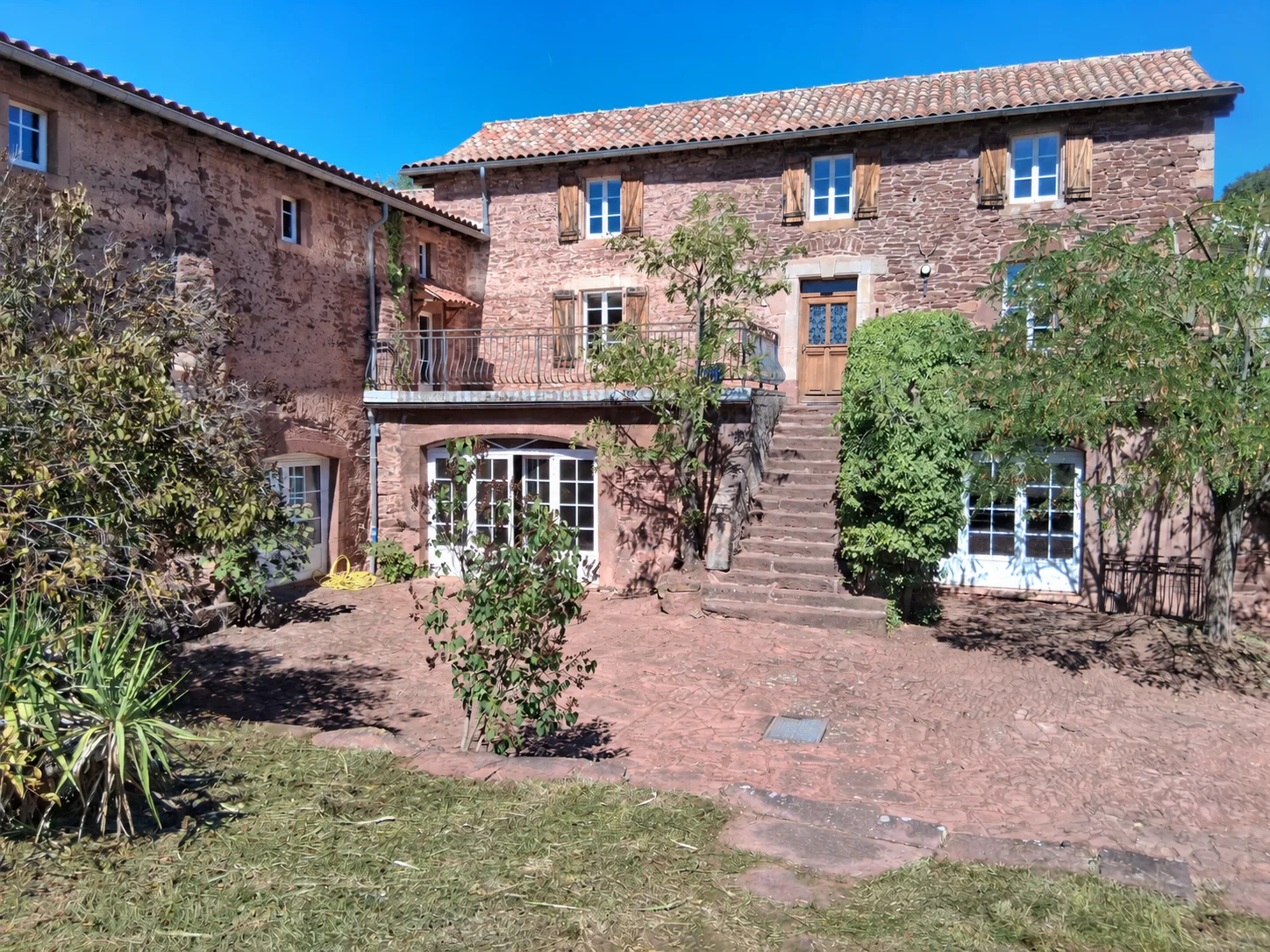 La maison historique et sa cour pavée de pierre, un cadre pour se retrouver en plein air.