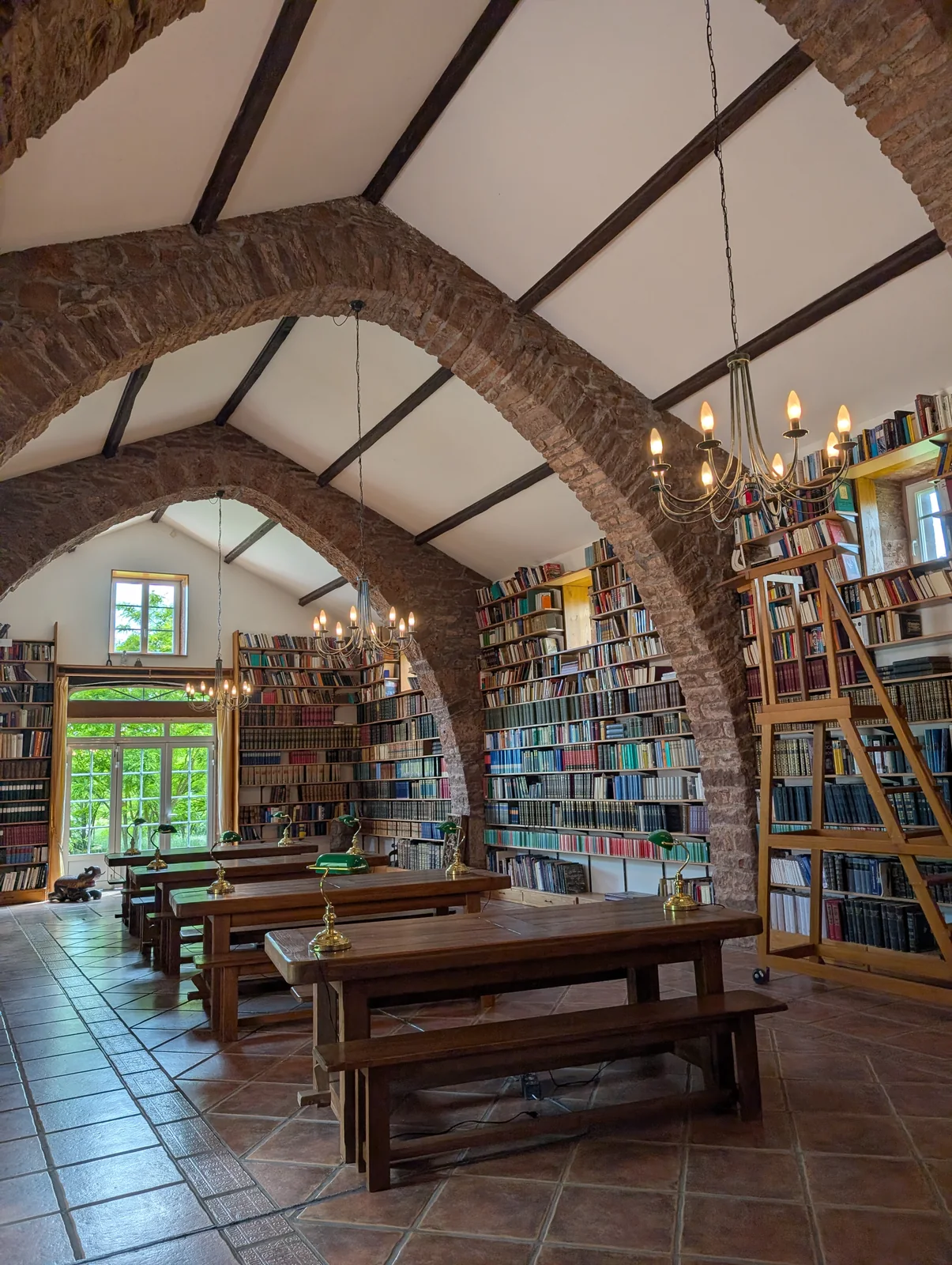 Arches en pierre et détails en bois dans la salle-bibliothèque de la maison historique.