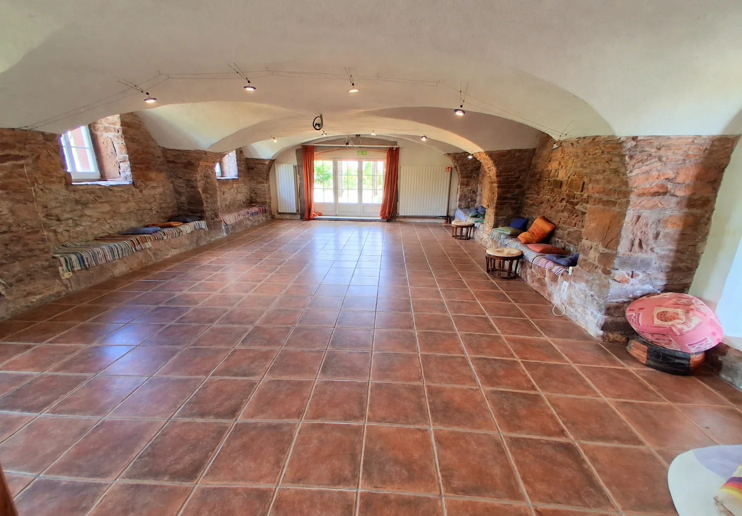 Une salle voûtée de la maison historique, avec un espace dégagé pour les activités partagées.