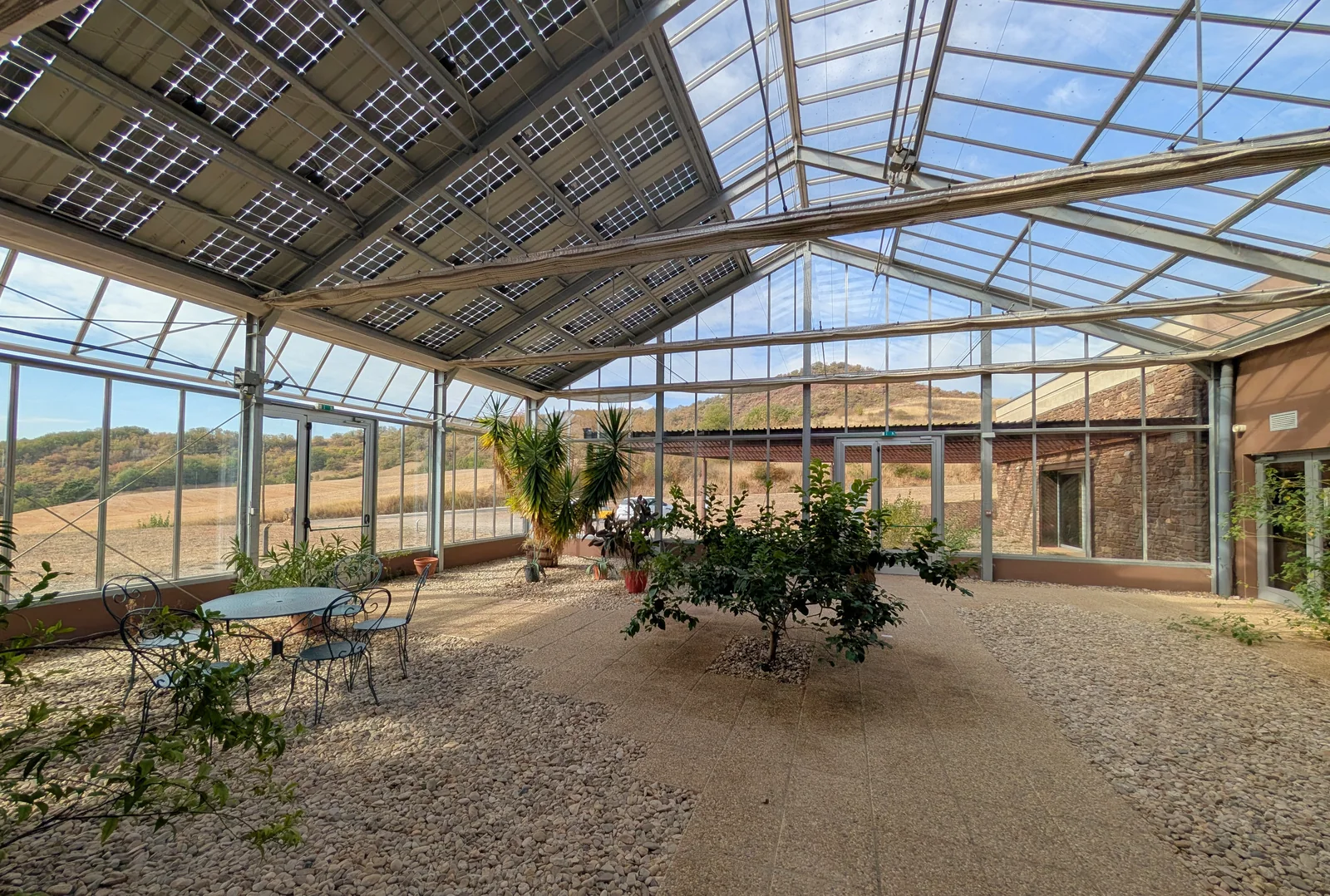 La verrière de 140 m², ouverte sur le paysage environnant.